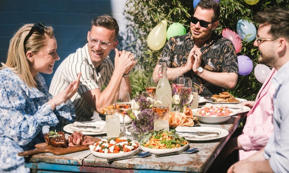 Venner fejrer sommerfest ved et langbord